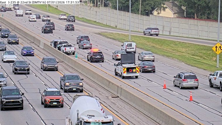 Police car with lights on in the left lane
