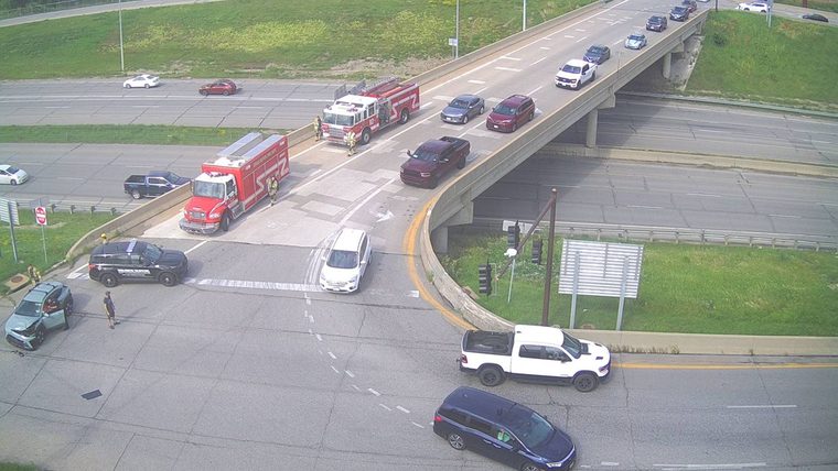 Two fire trucks and a police car with responders on the roadway