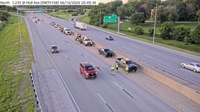 Multiple tow trucks and personnel on the highway shoulder attending to vehicles.