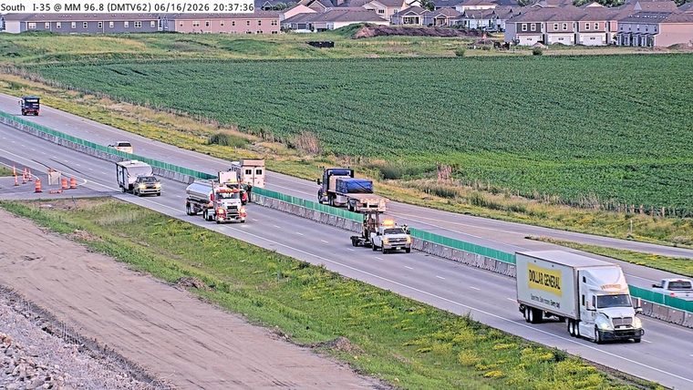 Tow truck with flashing lights assisting a disabled vehicle on the highway.