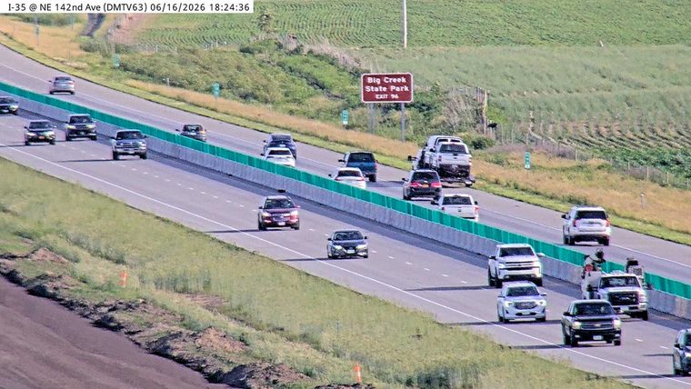 Emergency responders and vehicles are present on the right shoulder of the highway.