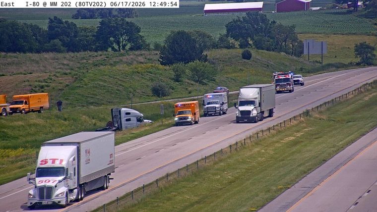 Multiple emergency vehicles and a crashed truck on the roadside.