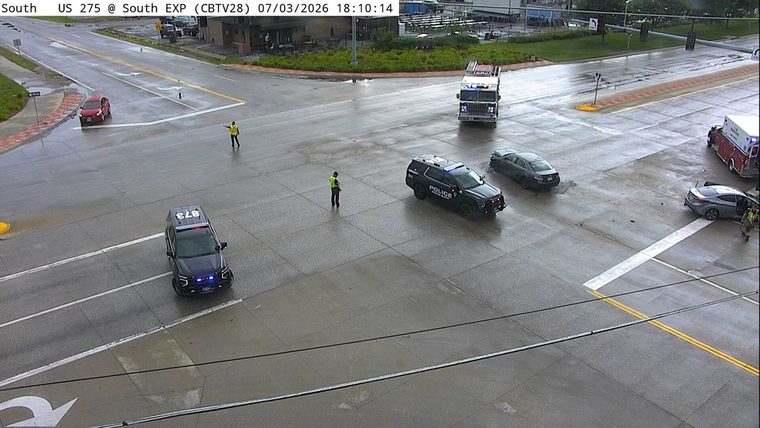 Police car, fire truck, and ambulance at intersection with multiple vehicles