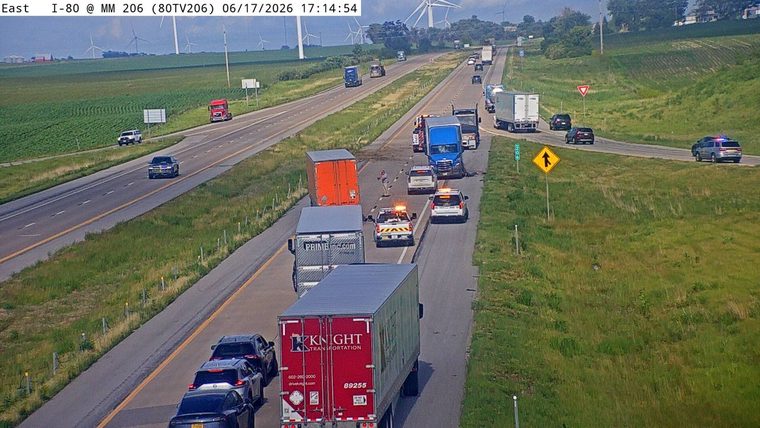 Police and emergency vehicles on scene of a traffic incident on the highway.