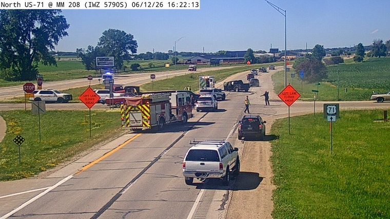 Emergency responders and vehicles are present on the roadway with lanes closed.