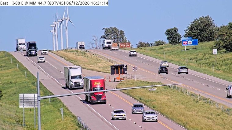 Traffic control equipment and cones are set up on the roadside, indicating a possible incident.