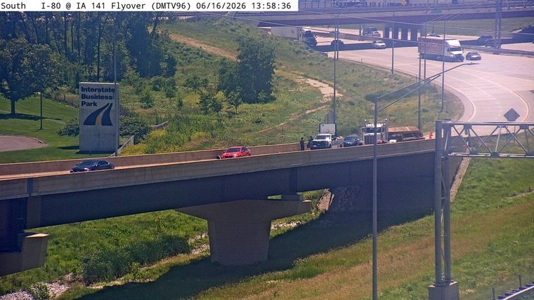 Police vehicle and personnel on scene with a red car stopped on the highway.