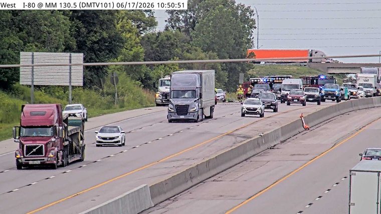 Emergency responders and vehicles are present on the highway, indicating an incident.