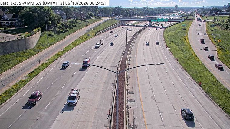 Two emergency vehicles are present on the highway, one stopped and one moving.