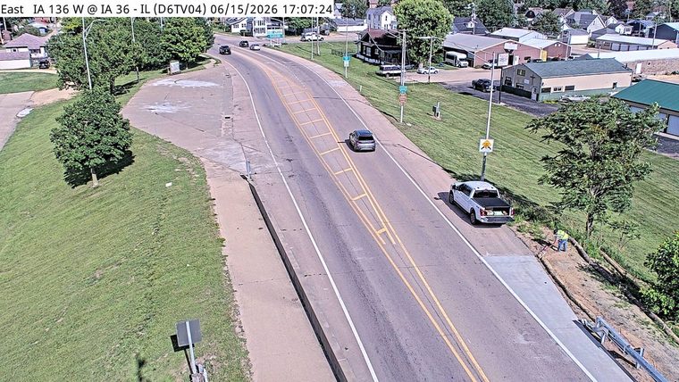 Person in safety vest working on roadside near a pickup truck.