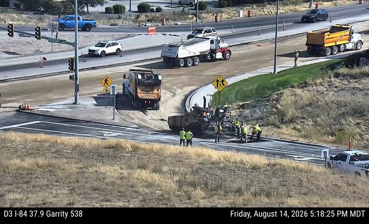 Construction crew and equipment paving roadway