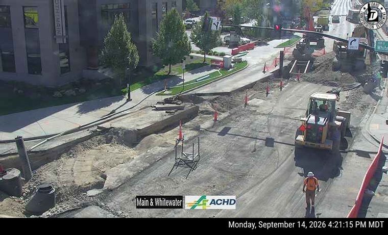 Construction worker and heavy equipment in the roadway