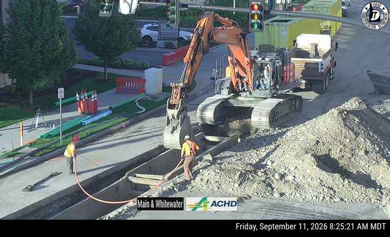 Construction workers and heavy equipment in the roadway