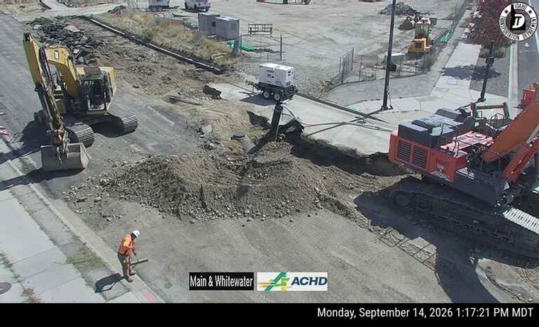 Construction equipment and a worker on the roadway