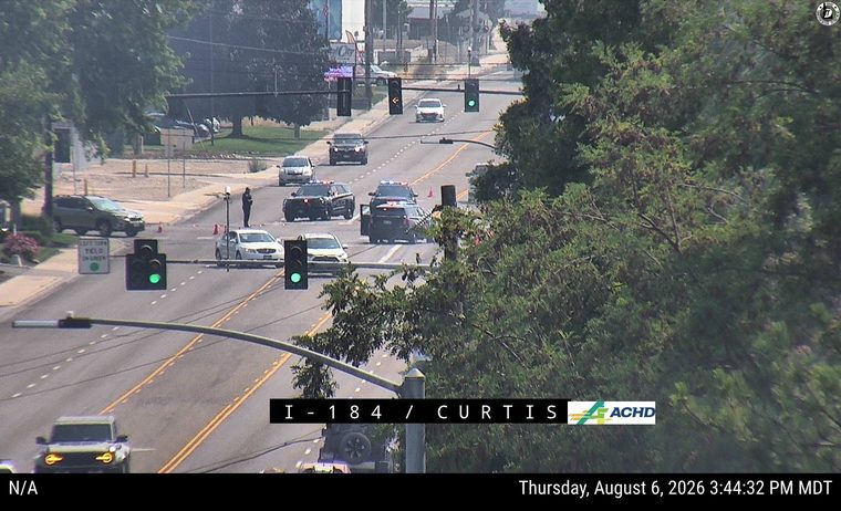 Three police cars with lights on in the intersection