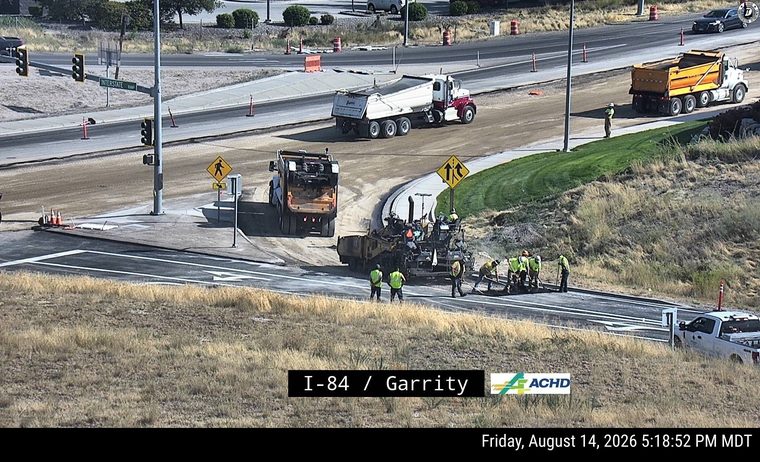 Construction crew and equipment paving road