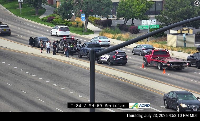 Police car and tow truck attending to a vehicle on the right shoulder