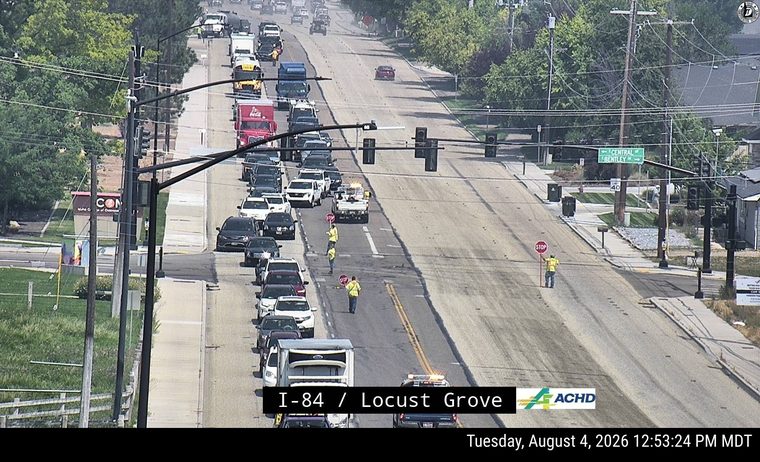 Two workers with stop signs directing traffic in the left lane