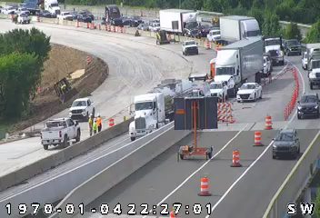 Emergency responders and construction workers are present at a roadside incident.