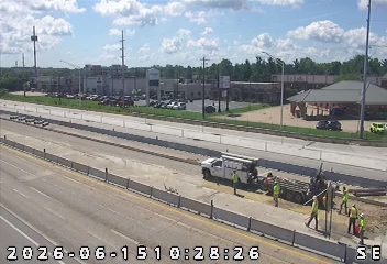 Construction crew and truck on the side of the road with equipment.