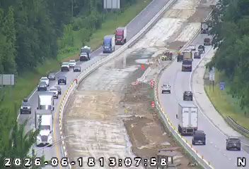 Construction zone with workers and equipment on the roadway.