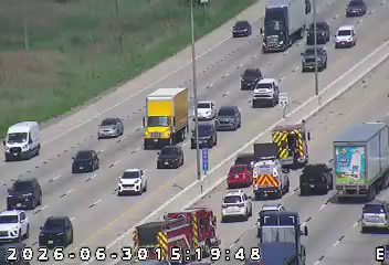 Two fire trucks and an ambulance with lights on in the right lanes