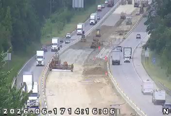 Road construction with heavy equipment and workers present on the highway.