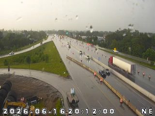 Emergency responders and cones on highway during heavy rain.