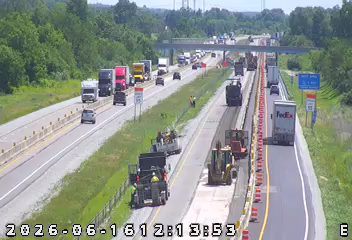 Road work with personnel and equipment on the shoulder and travel lanes.
