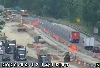 Road construction with heavy equipment and traffic control devices present.