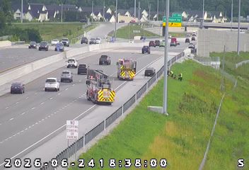 Two fire trucks and several workers on the right shoulder