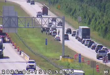 Emergency responders and vehicles are present on the roadside, indicating an incident.