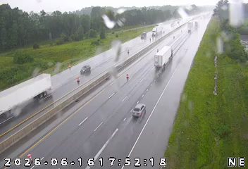 Emergency responders are present on the highway with cones and vehicles.