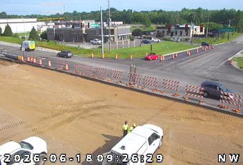 Two workers in vests are near a white truck on a construction site.