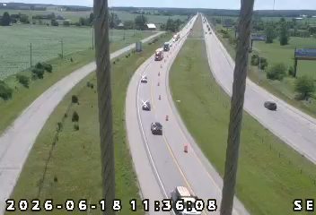 Emergency responders and traffic cones are present on the highway, indicating an incident.