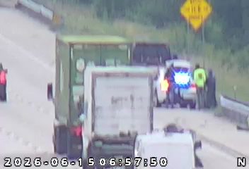 Emergency responders and vehicles are present on the roadside, indicating an incident.