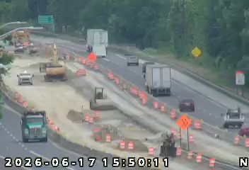 Road construction with heavy equipment and traffic control devices present.