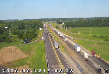 Construction crew and equipment visible on the right shoulder of the highway.