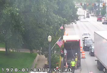 Workers and a truck appear to be performing road maintenance or cleanup.