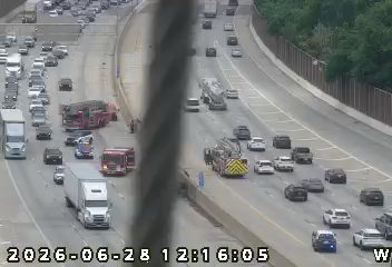 Two fire trucks and a police car on the right shoulder