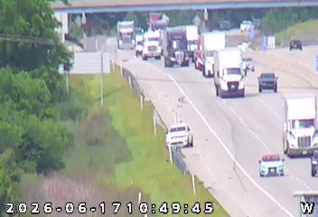 Emergency vehicle with lights on, stopped on the shoulder of the highway.