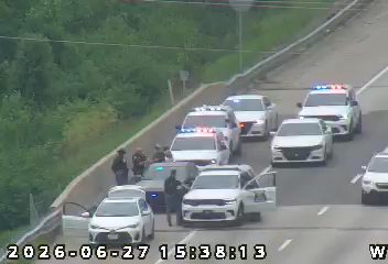 Multiple police cars with lights on the right shoulder