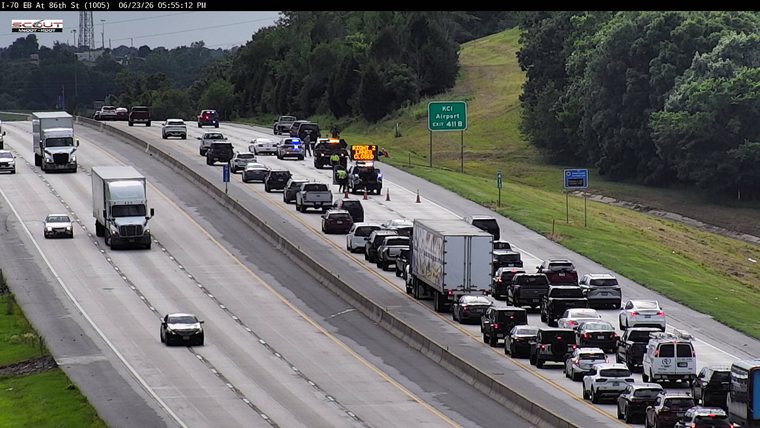 Police car and traffic control vehicles with a sign indicating 'RIGHT 2 LANES CLOSED' in the right lanes