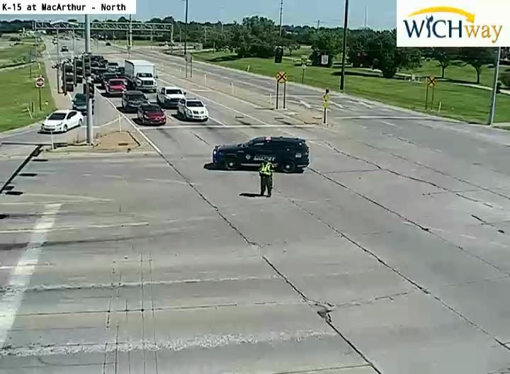 Police car and officer present at intersection, directing traffic.