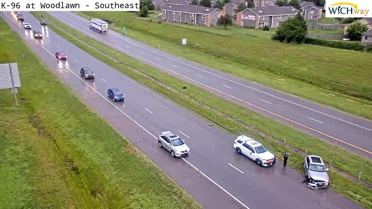 Police and damaged car on the shoulder, responding to an incident.