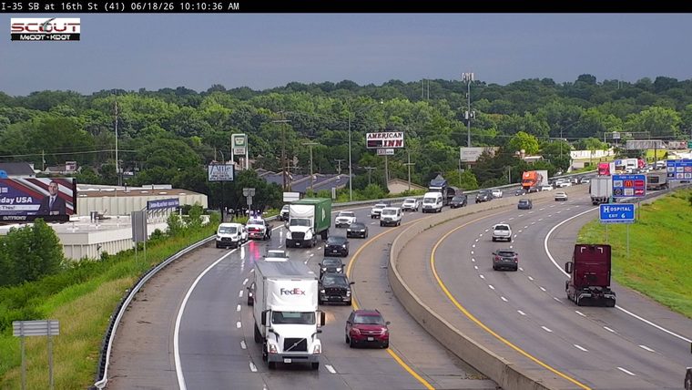 Police and emergency vehicles are stopped on the shoulder of the highway.