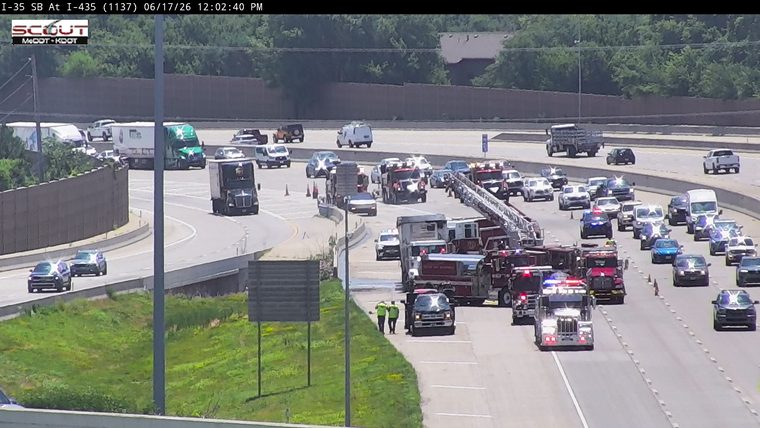 Multiple fire trucks and police vehicles on the highway with personnel present.