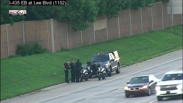 Police officers and motorcycles are stopped on the shoulder of the highway.