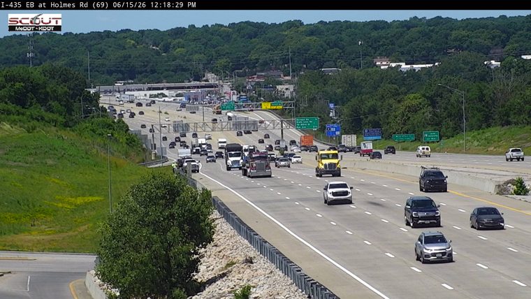 Two emergency vehicles and personnel on the shoulder of the highway.