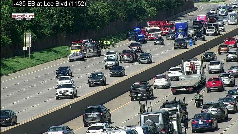 Multiple emergency vehicles and personnel on the left shoulder